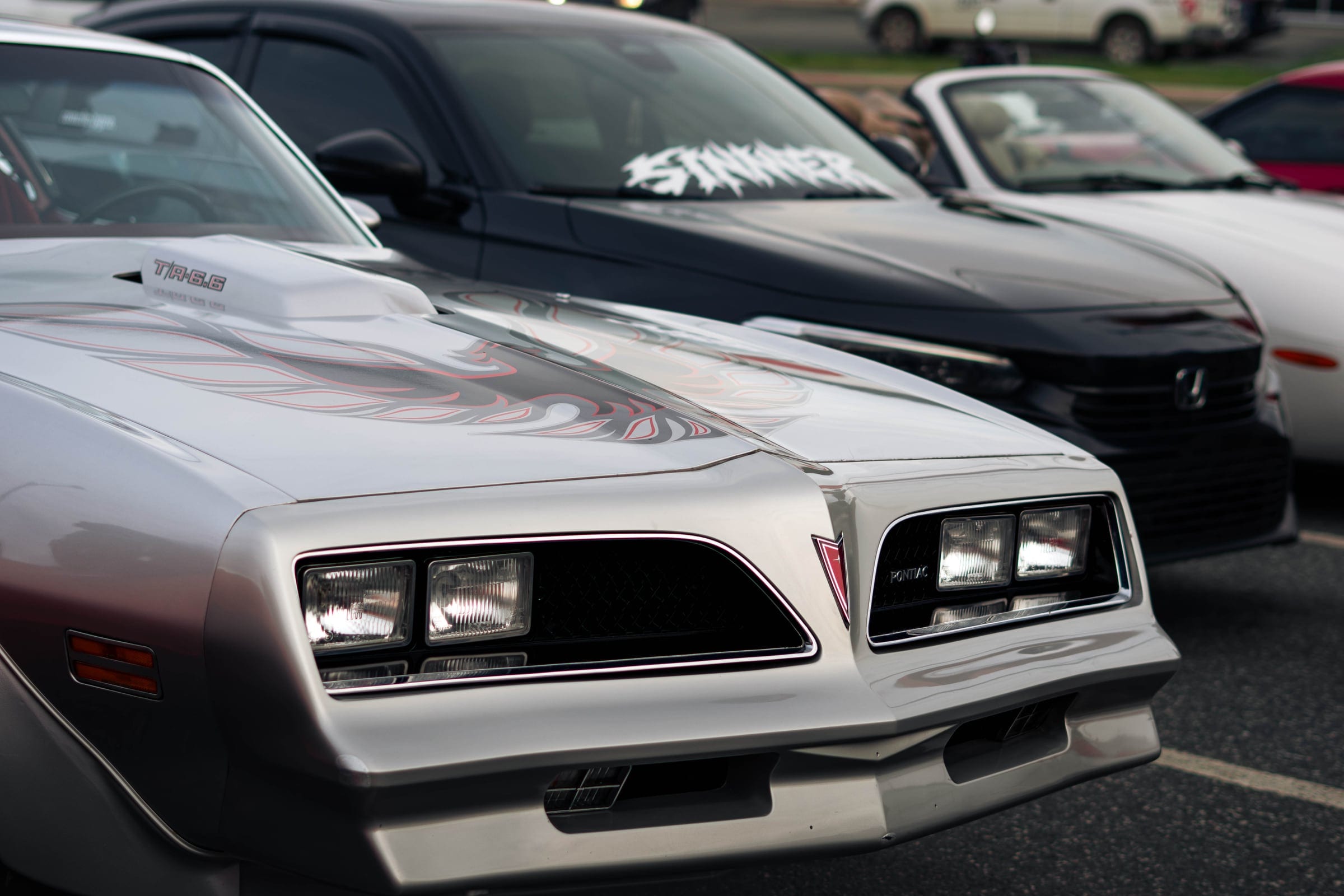 The front of a silver Pontiac Trans Am, headlights set deep in the grille.
