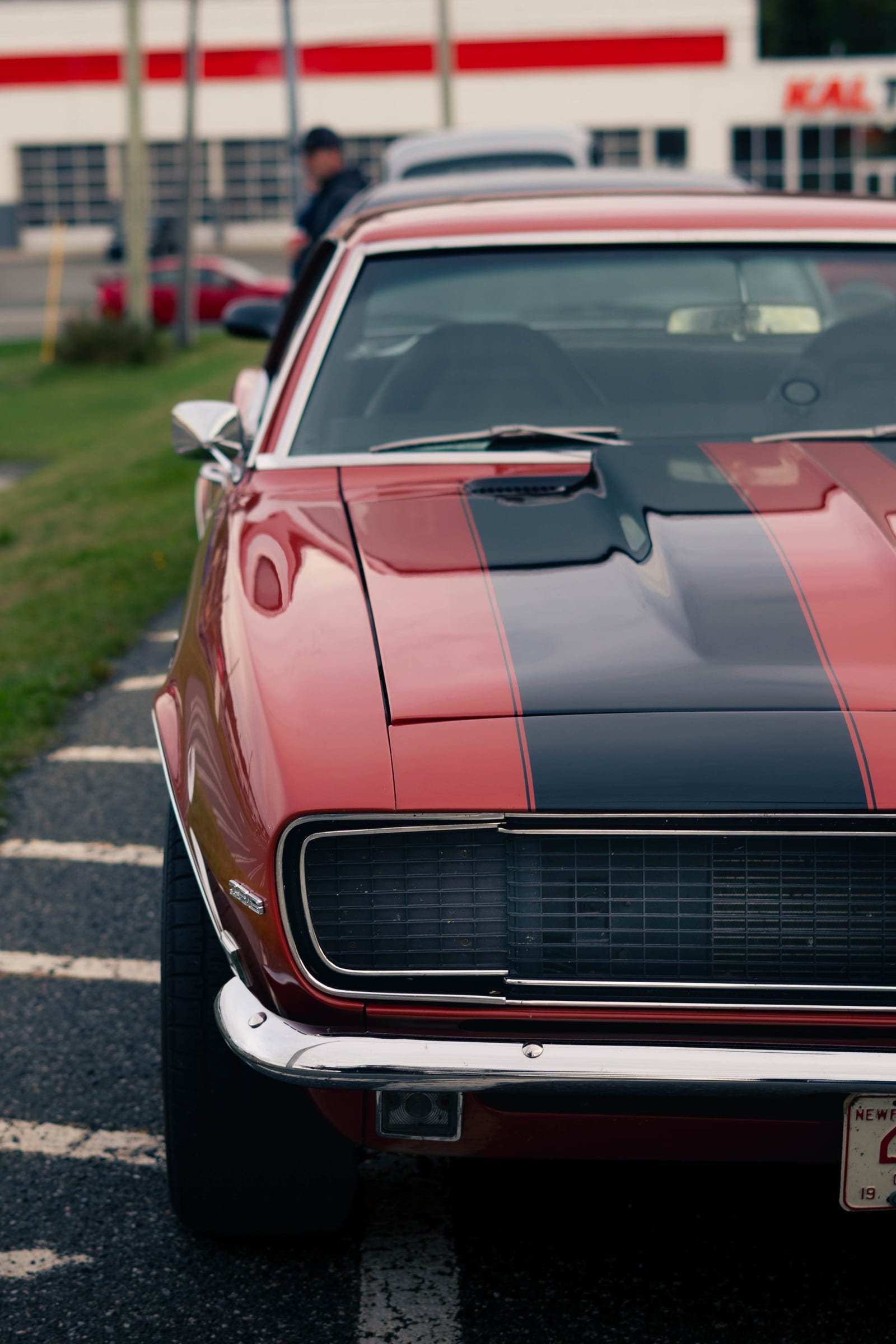 The front of a red Camaro with black stripes, parked facing the camera.